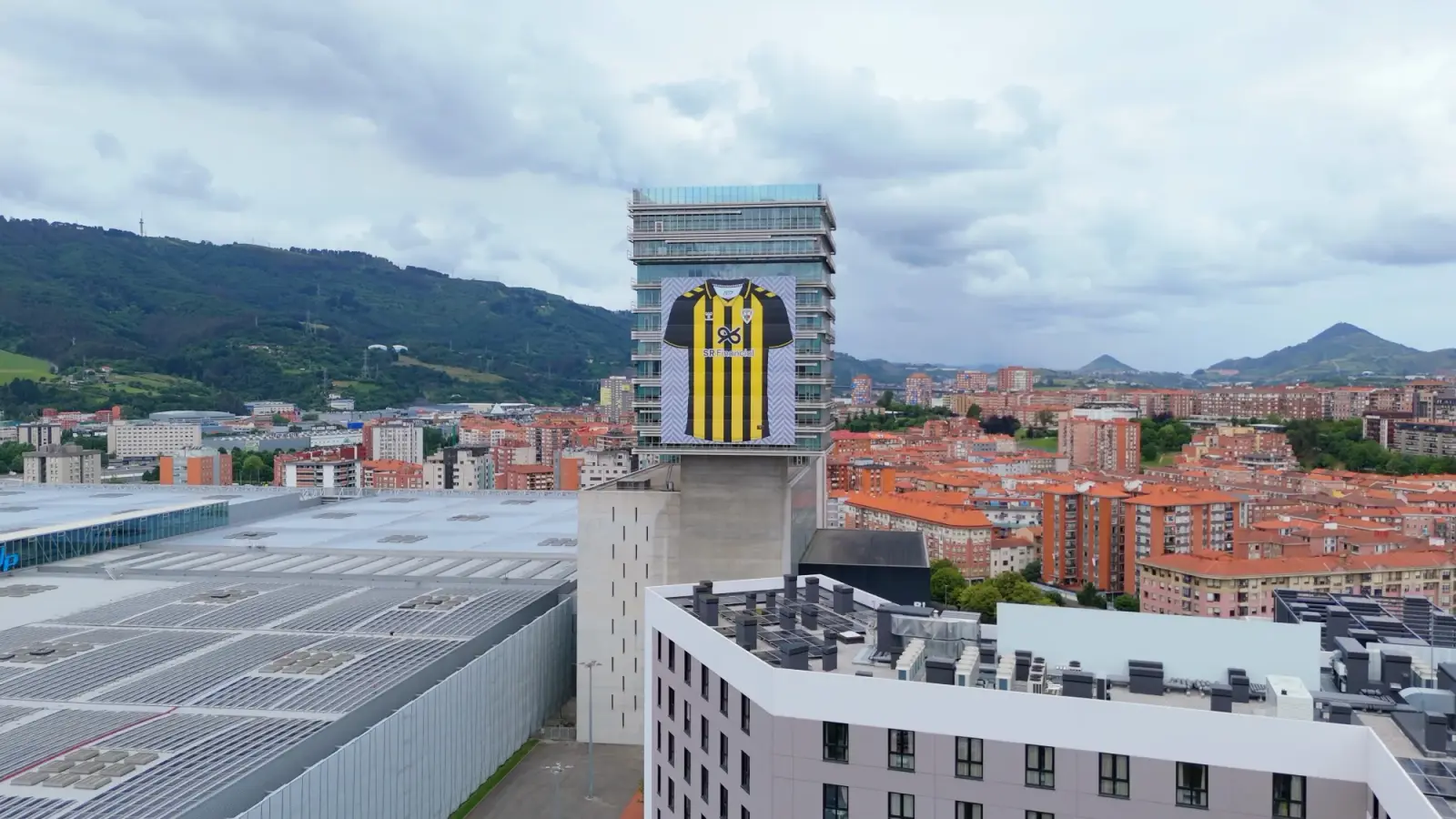 Lona gigante con la camiseta del Barakaldo CF en la torre del BEC, vista desde el dron