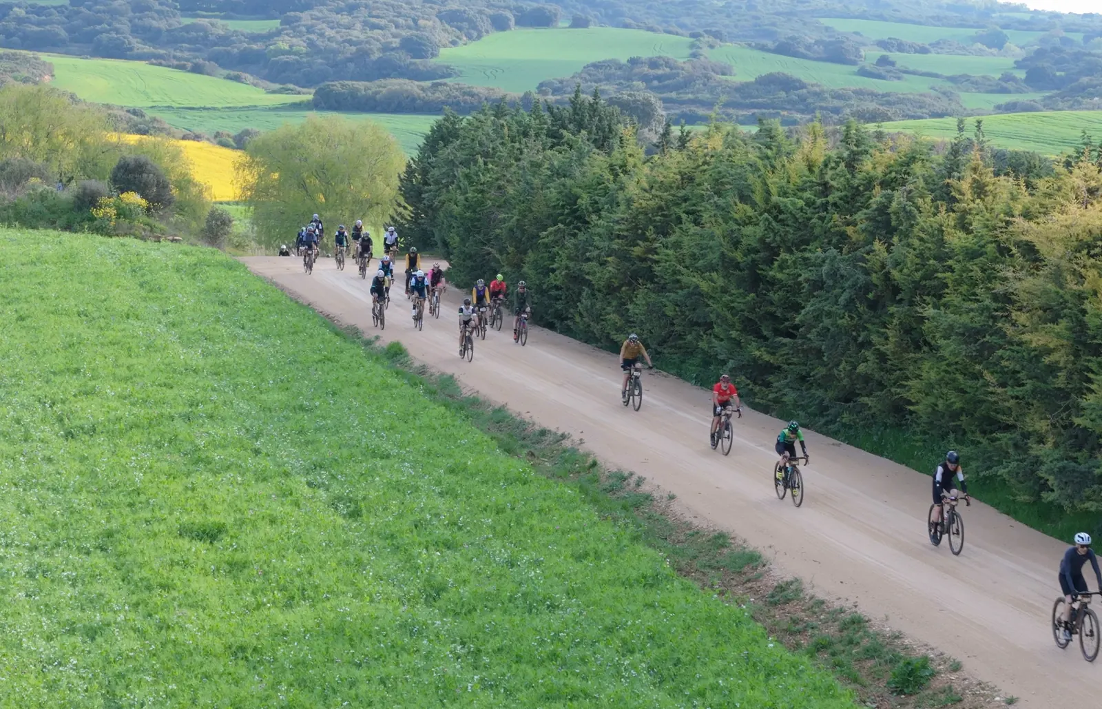 Ciclistas de la Tierra Estella Epic Gravel rodando por un camino de Navarra, grabados con dron